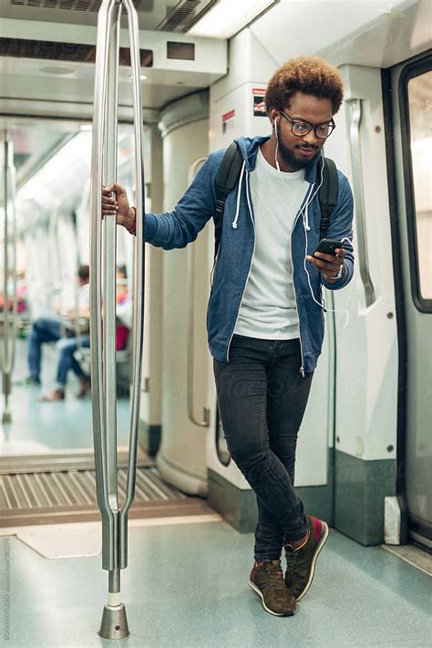 Young Afro Black Man Using Mobile Phone While Listening Music On The