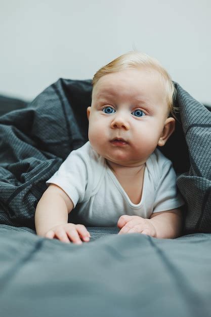 Un niño pequeño está tendido en una cama grande en casa Retrato de un