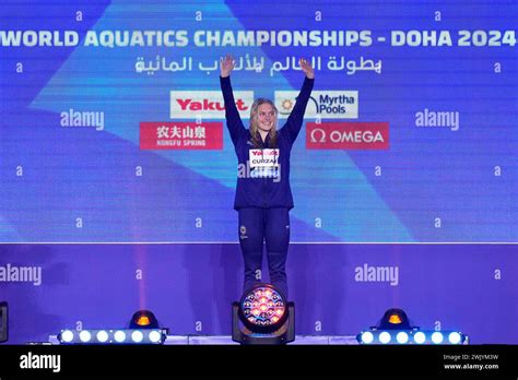 Claire Curzan Of The United States Stands On The Podium After Winning