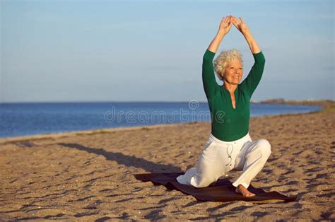 Donna Matura Che Allunga Sulla Spiaggia Yoga Immagine Stock