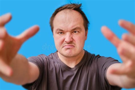 Portrait Of A Disheveled Looking Adult Man Pulling His Arms Forward