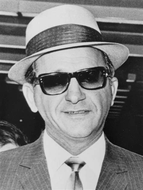 An Old Black And White Photo Of A Man In A Suit And Tie Wearing Sunglasses