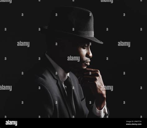 African American Man Posing Against A Black Background Wearing A Suit