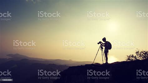 Fotografer Wanita Mengambil Foto Di Puncak Gunung Matahari Terbenam