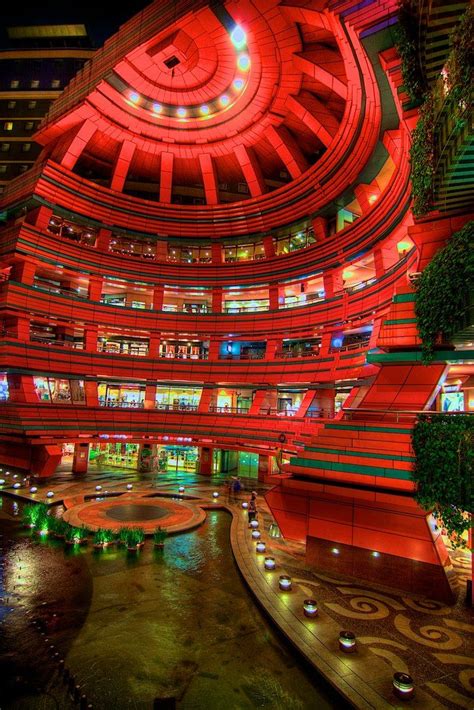 The Inside Of A Building Lit Up With Red Lights And Plants In Front Of It