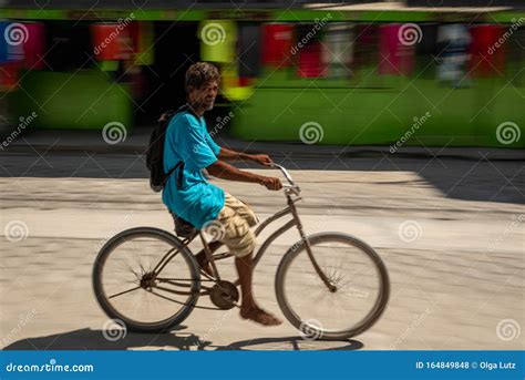 A Local Belizean Man Riding A Bike Barefoot Down The Street Editorial