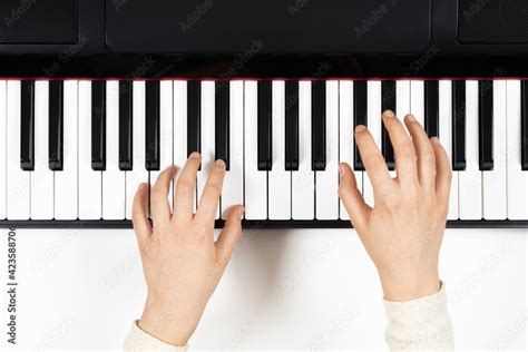 Kid hands learning to play on the piano. Top view Stock Photo | Adobe Stock