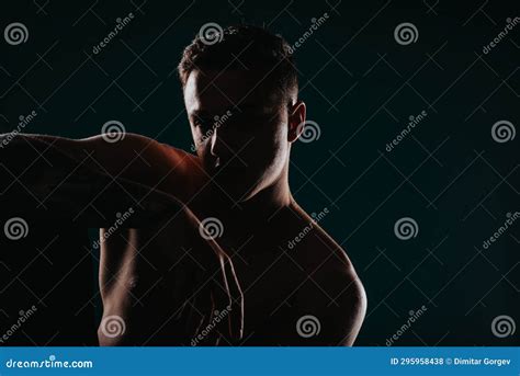 Confident Fit Man Showing Muscles In Powerful Studio Pose Stock Photo