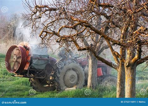 Tractor With Atomizer Sprayer Spraying Pesticides On Apple Trees Stock