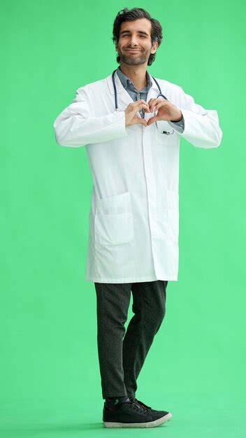 Premium Photo Male Doctor In A White Coat On A Green Background Shows