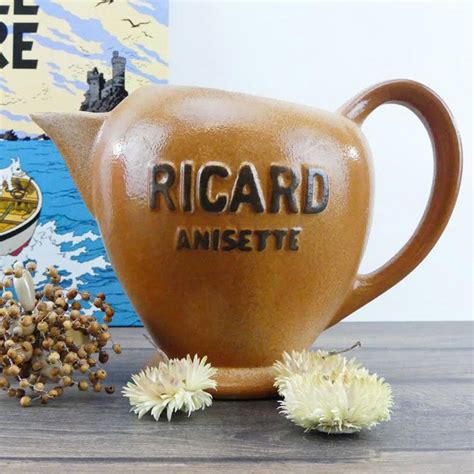 A Ceramic Teapot With The Words Ricard Ansett Written On It Next To