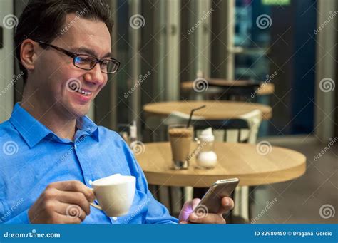 Young Man Texting In The Cafe Happy Businessman Smiling And Texting On