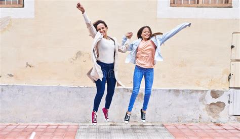 Woman And Girl Mother And Daughter Jumping At Street Stock Image