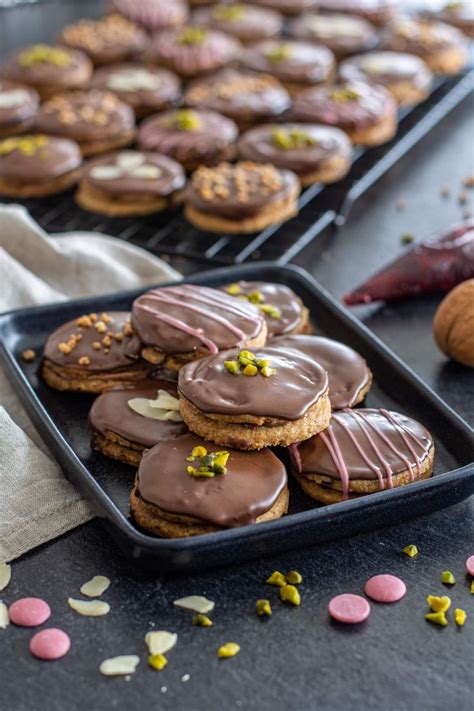 Several Trays Of Cookies With Chocolate Frosting And Sprinkles On Them