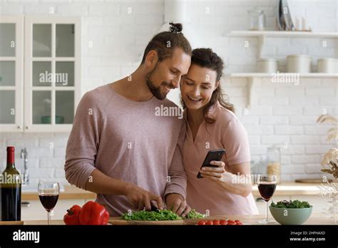 Bonding family couple cooking on weekend, using cellphone Stock Photo ...