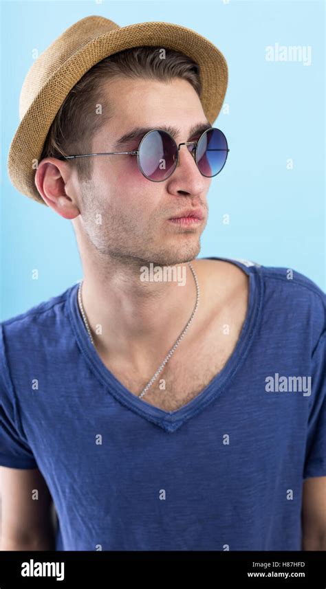 Happy Confident Young Man In Hat And Sunglasses Standing Over Blue