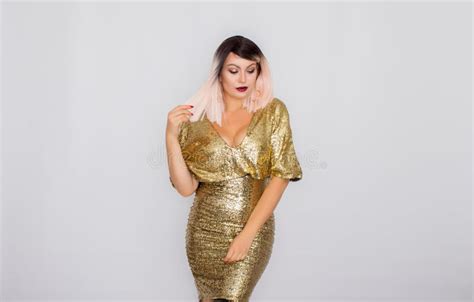 Portrait Of A Beautiful Blonde With Bright Makeup In A Gold Dress Stock