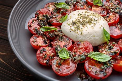 Tomates Al Horno Con Queso Mozzarella Sobre Un Fondo De Madera Foto