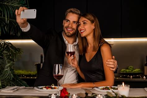 Premium Photo Happy Couple Having Dinner And Taking Selfie Using Smartphone Indoors