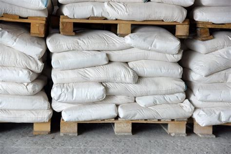 Bags Of Cement In The Warehouse Are Stacked On Pallets Stock Photo