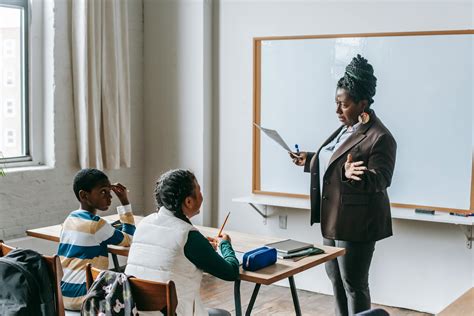 Black teacher explaining presentation to diverse elementary pupils ...