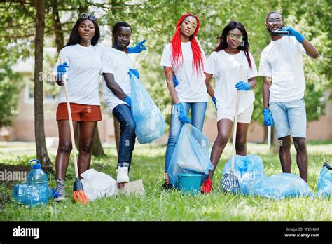 Group Of Happy African Volunteers With Garbage Bags Cleaning Area In