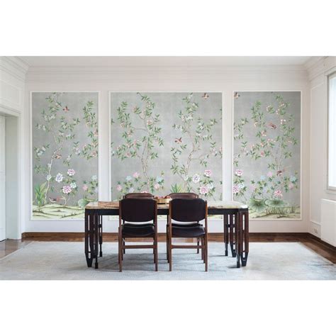 Two Chairs Are Sitting At A Table In Front Of A Wall With Flowers