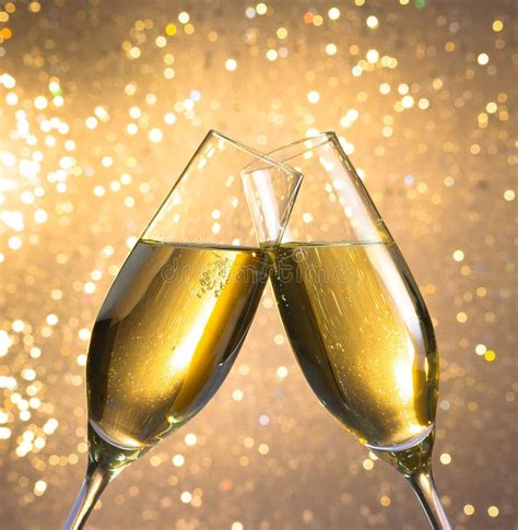 Champagne Flutes With Golden Bubbles On Light Bokeh Background Stock