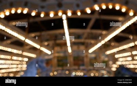 Golden Illuminated Defocused Retro Carousel Turning In Amusement Park