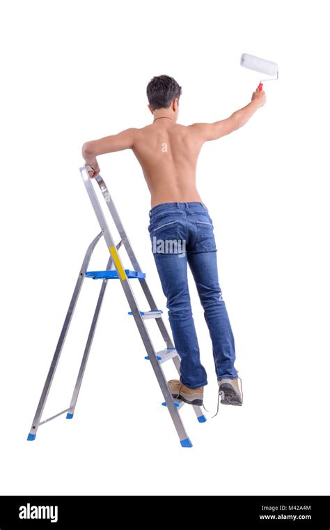 Macho joven decorador pintando con un rodillo de pintura subió una