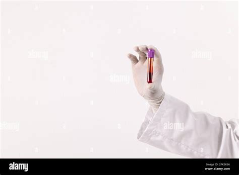 Hand In White Surgical Glove Holding Blood Sample Tube On White