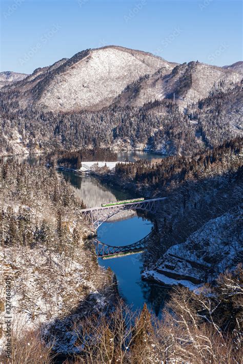 Beautiful Landscape Of Tadami Line Train Across Tadami River In Winter