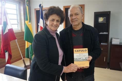 Autora entrega na ADR Araranguá exemplar de livro sobre EEB Catulo da