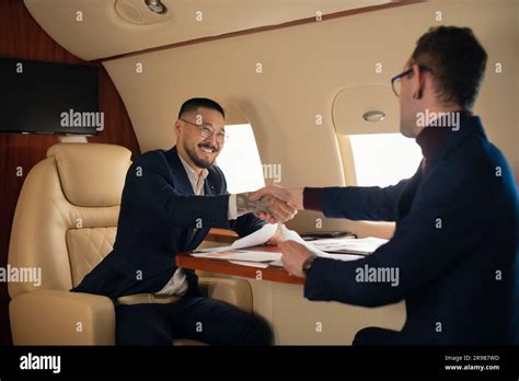 Two Ceo Young Businessman Couple Sitting Inside A Private Jet Airplane