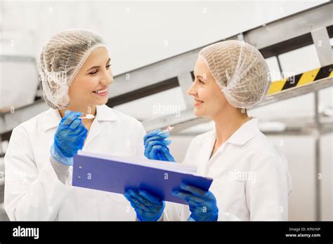 Women Technologists Tasting Ice Cream At Factory Stock Photo Alamy