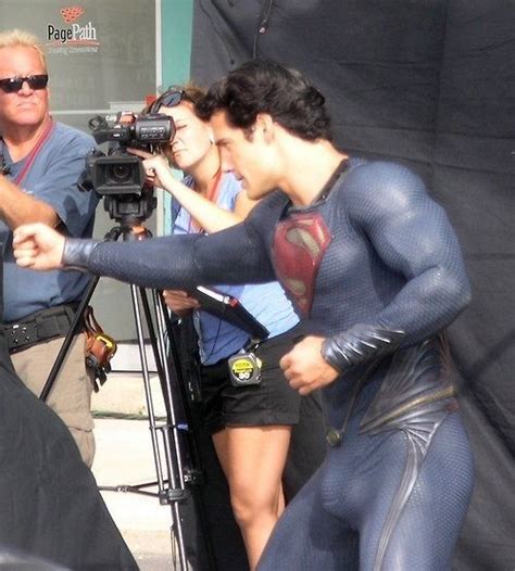 Two Men In Wetsuits Standing Next To Each Other Near A Camera Man And Woman