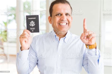 Middle Age Man Holding Holding Passport Of United States Surprised With An Idea Or Question