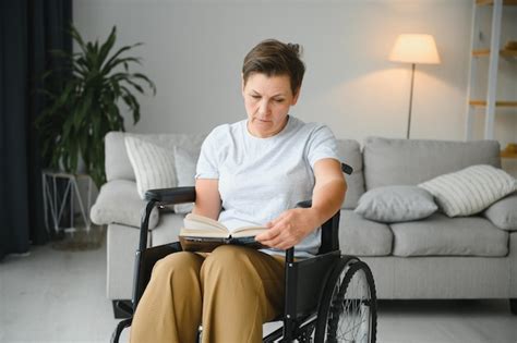 Una Foto De Una Anciana Sentada En Una Silla De Ruedas Y Leyendo Un