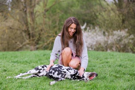 La Jeune Femme Donne à Son Chien Dalmatien Un Baiser Photo Stock