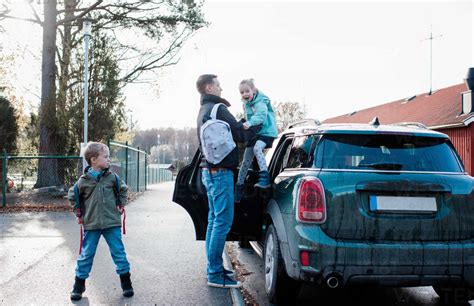 Father Dropping His Kids Off At School In The Morning Stock Photo