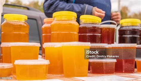 Plastic Jars Filled With Multicolored Honey Are On Counter Autumn Agricultural Fair Product Of