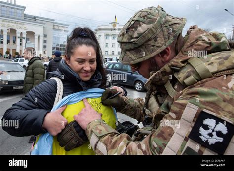 Ein ukrainischer Militärangehöriger gibt einem Bewohner im Zentrum von