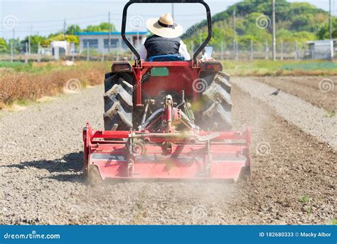 Tracteur Rouge Labourant Les Terres Agricoles Du Champ De Riz Image