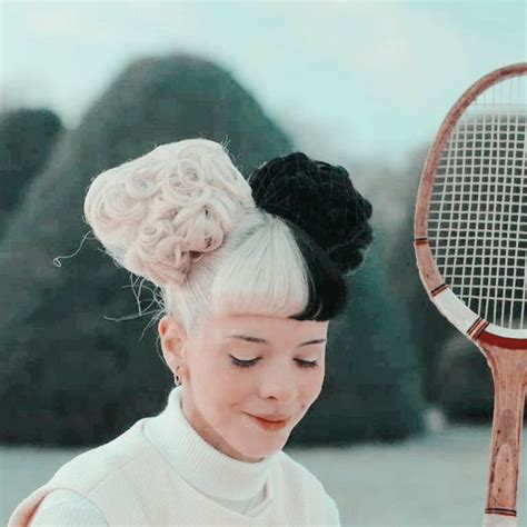 A Woman Holding A Tennis Racquet On Top Of A Field