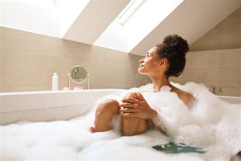 Woman Relaxing In Bathtub Full Of Foam In Bathroom Of House Stock Image