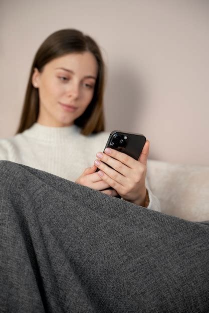 Jeune Femme Regardant Une Vidéo à Laide De Son Smartphone Photo Gratuite