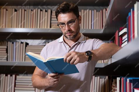 Premium Photo | Middle aged teacher in school library reading book ...