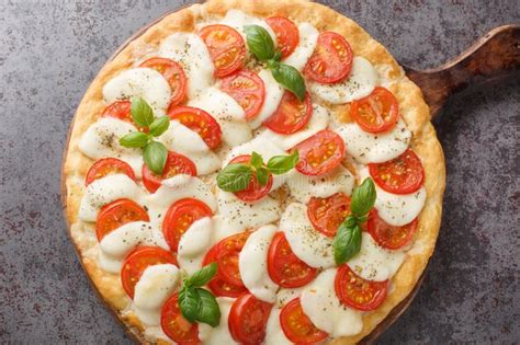 Delicious Hot Caprese Pizza With Mozzarella Tomatoes And Basil Leaves