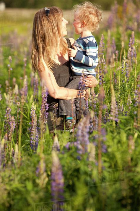 Caucasian Mother Hugging Son In Tall Grass Stock Photo Dissolve