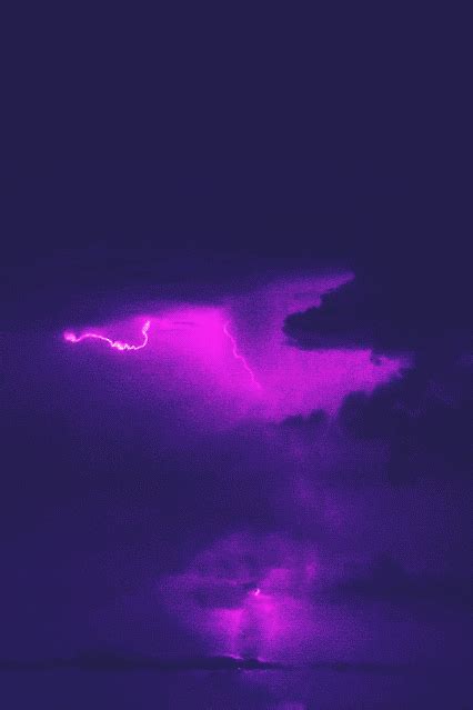 A Purple Sky With Some Clouds And Lightning